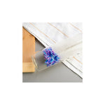 Aquafloow Bottle cleaning brush for carbonators – transparent bottle lying on fabric with blue‑purple brush head