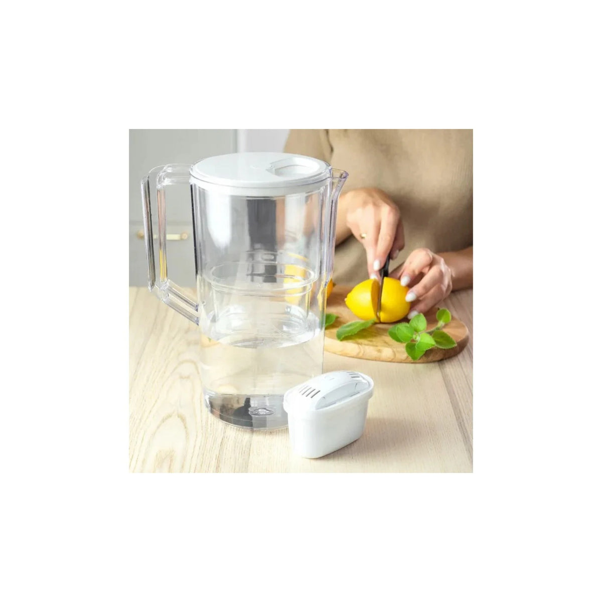 Aquafloow Maxi filter cartridge for water jugs and transparent jug on a wooden table, lemon being sliced in the background