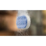 Blue and white round descaling tablet on a blurred neutral background