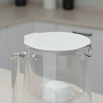 Transparent glass filter pitcher with white lid, handle and inserted white filter cartridge