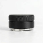 Distributor a zarovnávač kávy v páce 51mm černý kovový disk s vroubkovaným okrajem a nerezovým spodkem na bílém pozadí